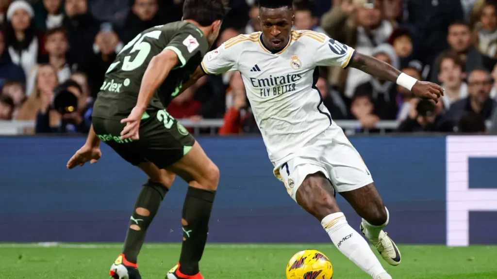 Vinícius Júnior’s winger dribbles past a Girona defender on the left wing.