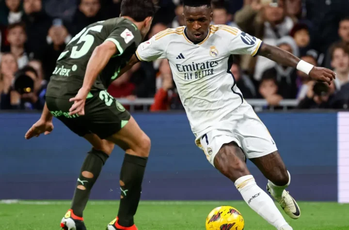 Vinícius Júnior’s winger dribbles past a Girona defender on the left wing.