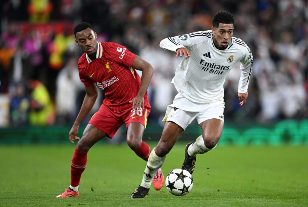 Real Madrid midfielder in white dribbles past a Liverpool player during a Champions League match