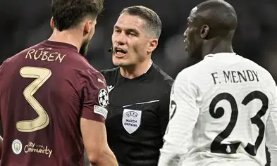 Match official mediates between opposing defender and Real Madrid full-back.