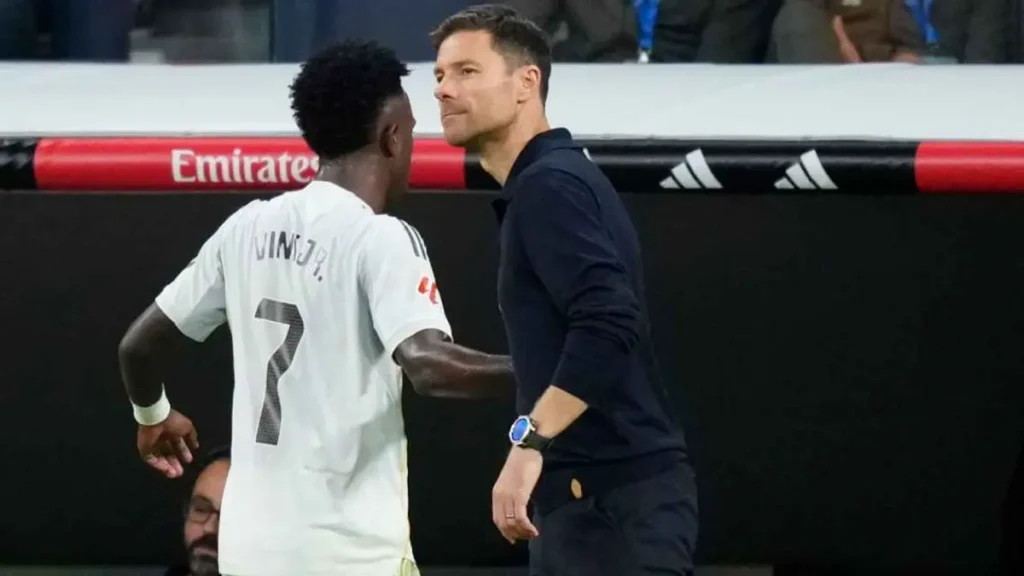 Real Madrid winger Vinícius Jr talking with his coach on the touchline, as discussions around -Vinicius Junior Real Madrid renewal 2026