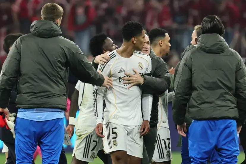 Jude Bellingham is held back by Real Madrid staff and teammates during a tense post-match scene.