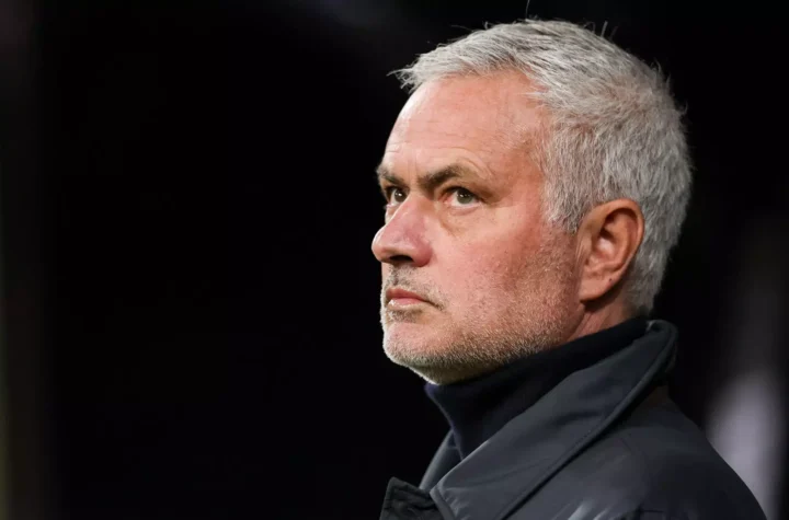 Close-up of a football manager watching from the sideline during a match.