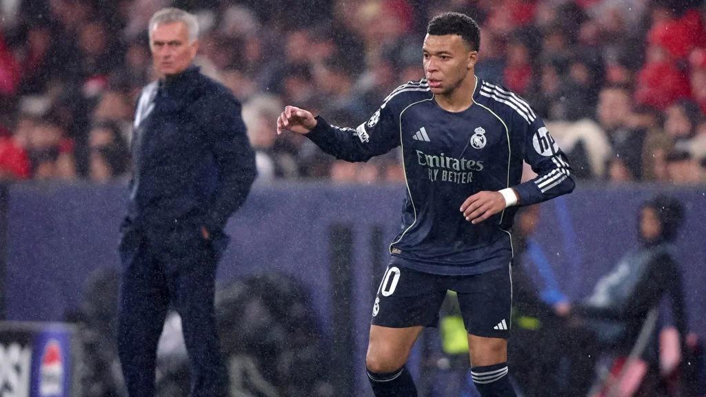 Real Madrid player during a match with a coach blurred in the background amid Jose Mourinho Real Madrid rumors