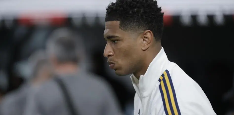 Real Madrid player in a white training jacket shown in side profile before a match
