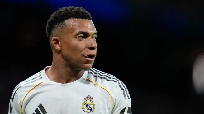 Real Madrid forward in a white training top looking to the side before a match