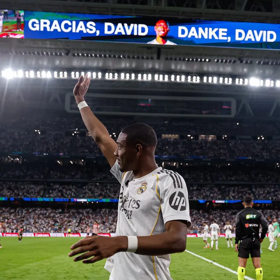 David Alaba waves to fans during his Real Madrid farewell at the Bernabéu as tribute screens display “Gracias, David” and “Danke, David”