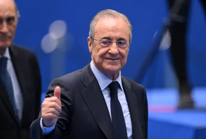 Senior Real Madrid official giving a thumbs-up during a high-profile club event