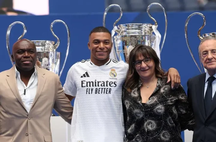 Kylian Mbappe Real Madrid backlash featured image showing a Real Madrid player at an official presentation with three others and Champions League trophies in the background