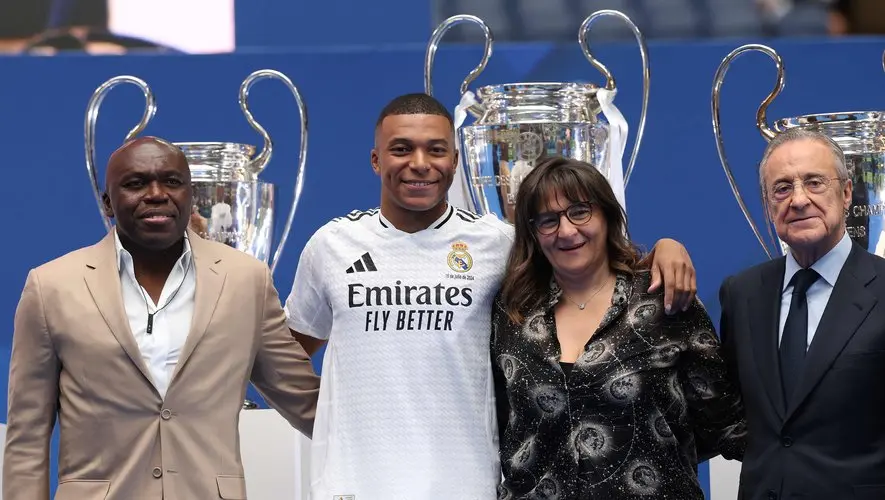 Kylian Mbappe Real Madrid backlash featured image showing a Real Madrid player at an official presentation with three others and Champions League trophies in the background