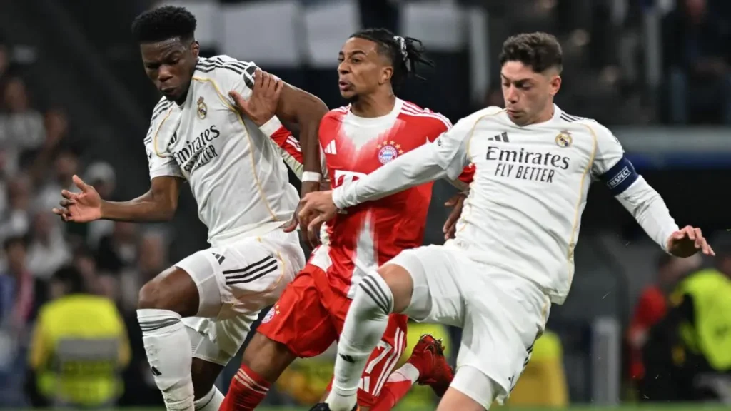 Match action featuring two Real Madrid midfielders battling for the ball against a Bayern Munich player