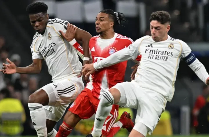 Match action featuring two Real Madrid midfielders battling for the ball against a Bayern Munich player