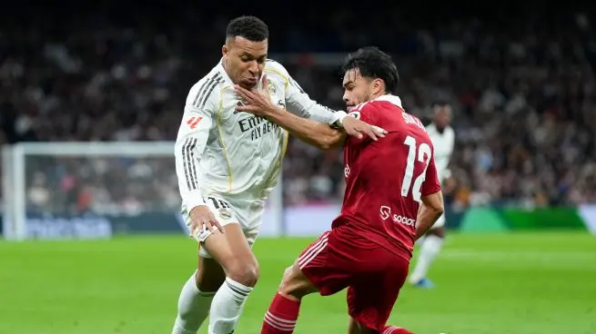 Real Madrid lineup vs Sevilla image showing a Real Madrid player challenging a Sevilla player during the match