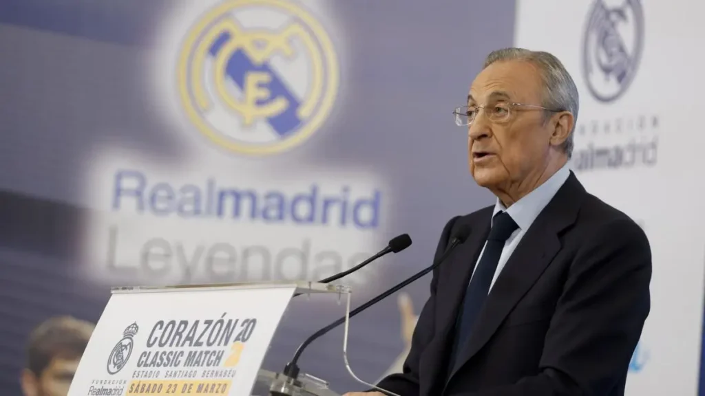 Real Madrid transfer news image showing a club official speaking at a podium in front of a Real Madrid backdrop