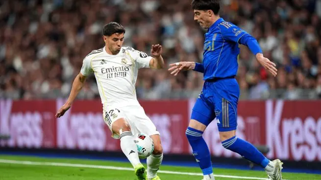 Real Madrid vs Oviedo action photo showing a Real Madrid player challenging an Oviedo opponent during the match at the Bernabeu