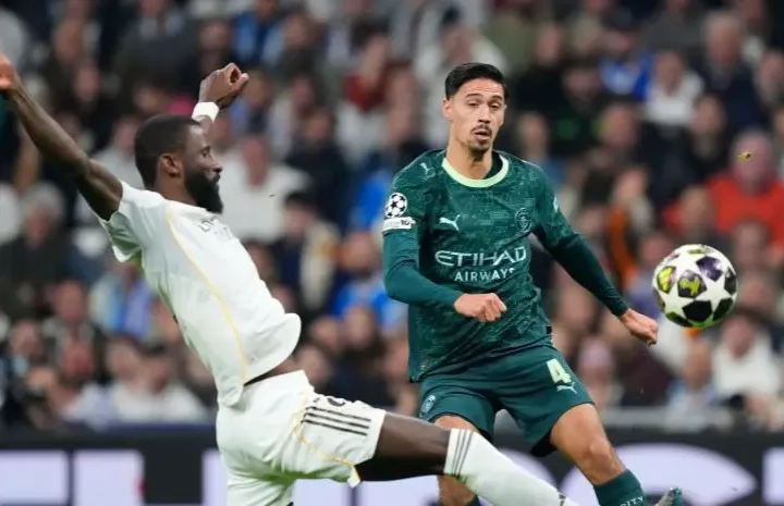 Tijjani Reijnders Real Madrid story image showing a Manchester City player challenged by a Real Madrid defender during a match