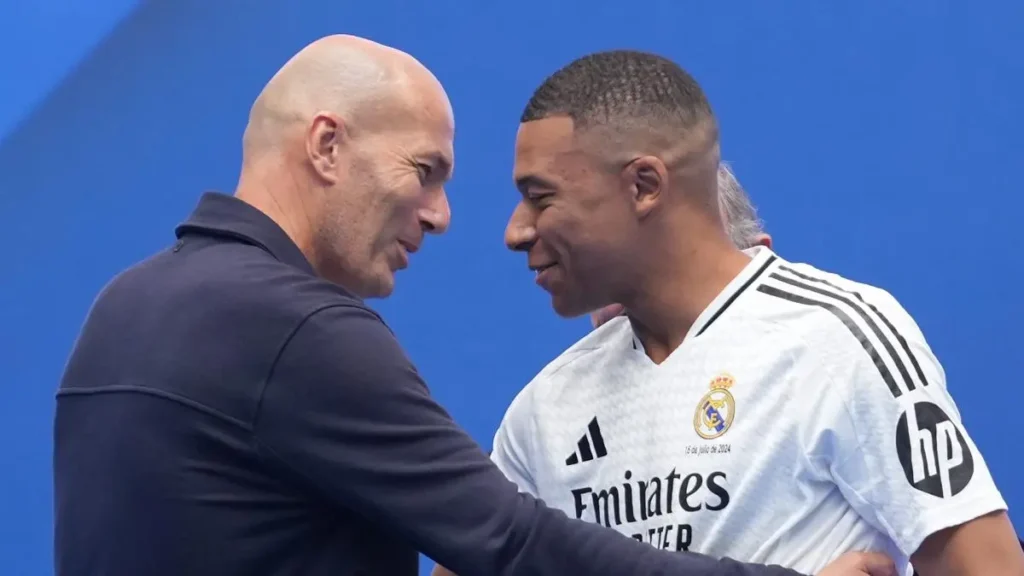 Zinedine Zidane Real Madrid return image showing Zidane greeting Kylian Mbappé during a Real Madrid presentation