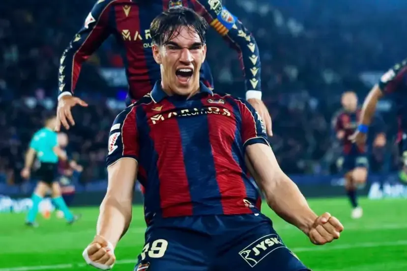 Carlos Espí Real Madrid featured image showing a young striker celebrating a goal during a league match