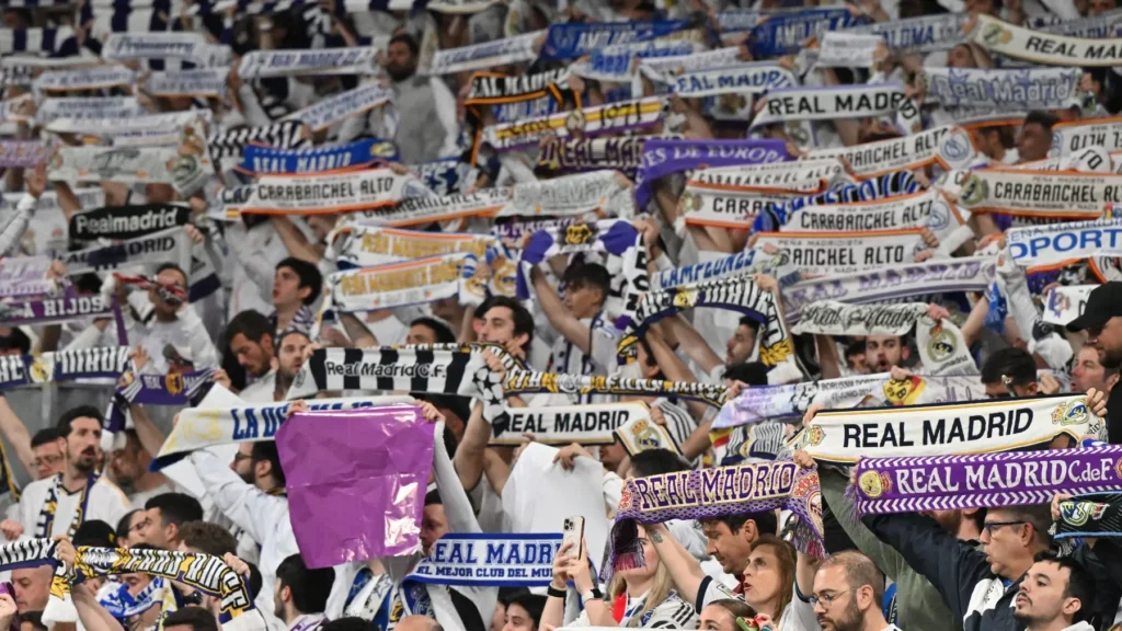 How to become a Real Madrid member featured image showing supporters holding club scarves inside the Santiago Bernabéu