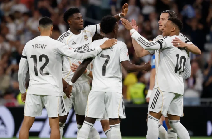 Real Madrid record revenue featured image showing the team celebrating together during a match