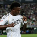 Real Madrid forward holds the club badge during a match, illustrating the emotional Vinicius renewal message.