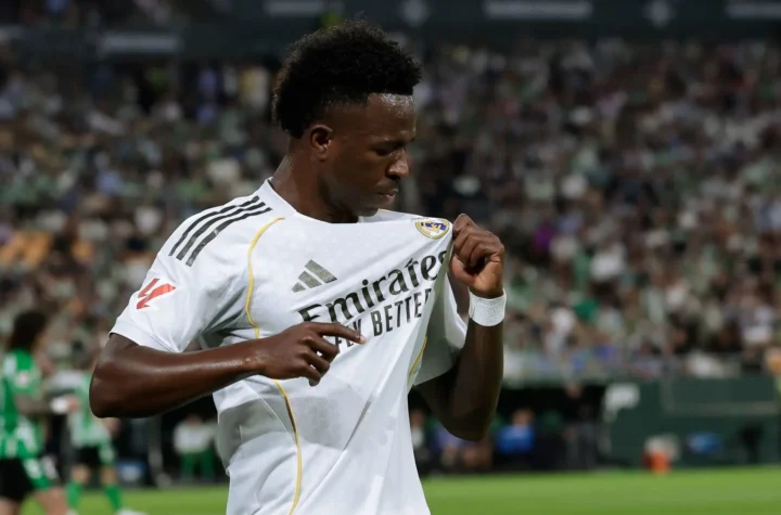 Real Madrid forward holds the club badge during a match, illustrating the emotional Vinicius renewal message.